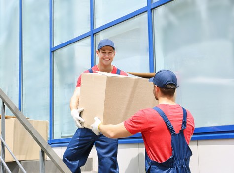 Specialist piano removals team handling an upright piano in Ilford