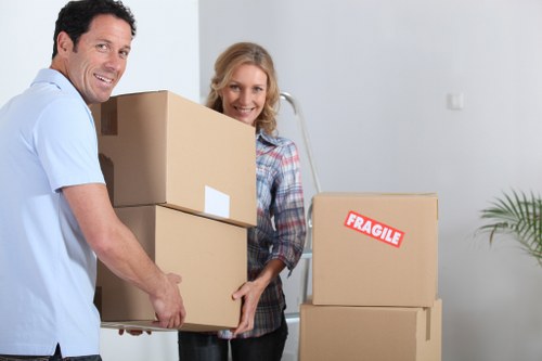 Local movers carrying office items through an Ilford commercial building